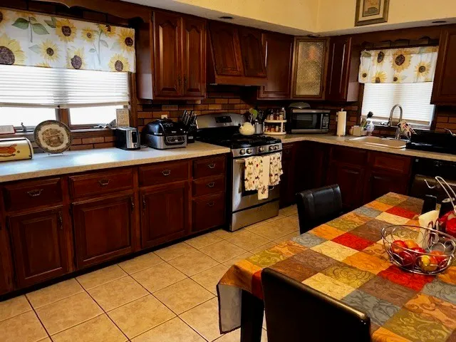 a kitchen with stainless steel appliances granite countertop a sink dishwasher stove and cabinets