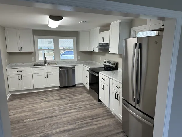 a large kitchen with cabinets and stainless steel appliances