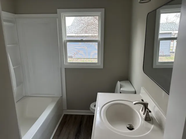 a bathroom with a sink a toilet and tub