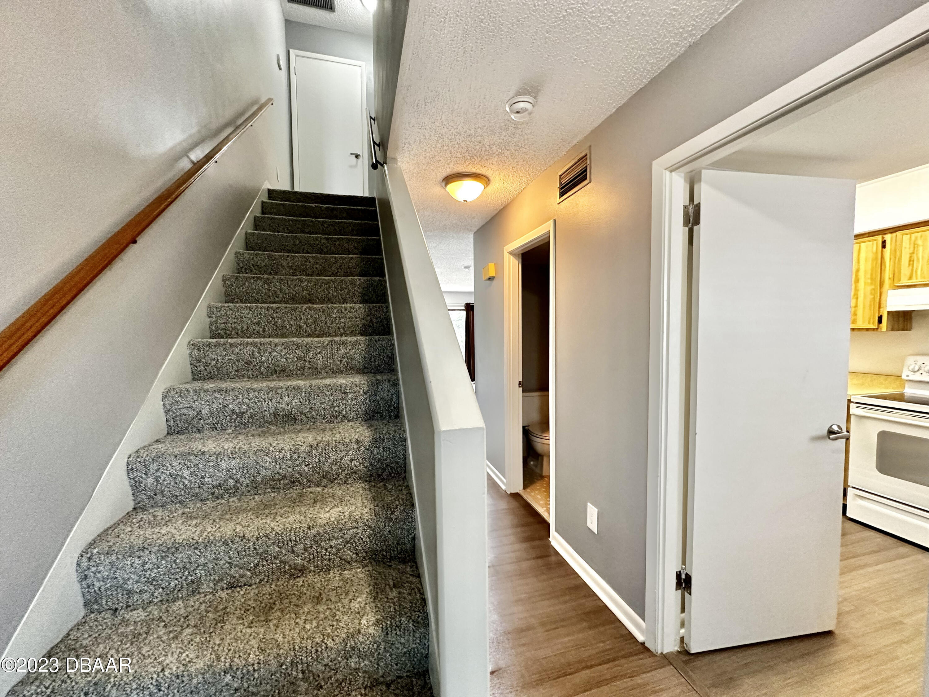 4790 South Atlantic Avenue, Unit D403 Ponce Inlet, FL 32127 - Photo 12 of 27 a view of a hallway with wooden floor and staircase