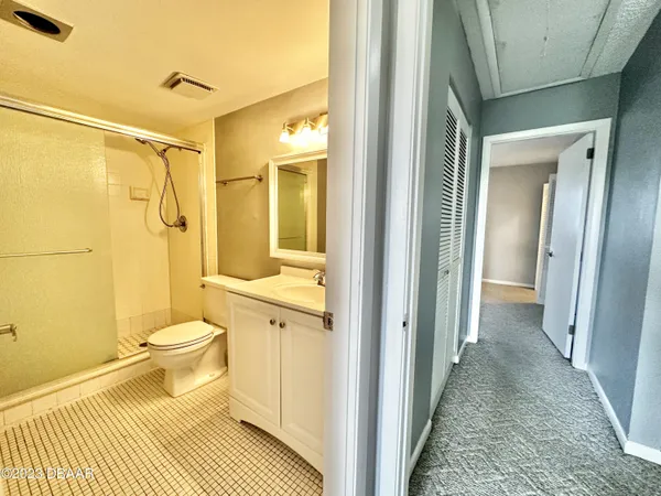 a bathroom with a granite countertop shower a toilet and a sink