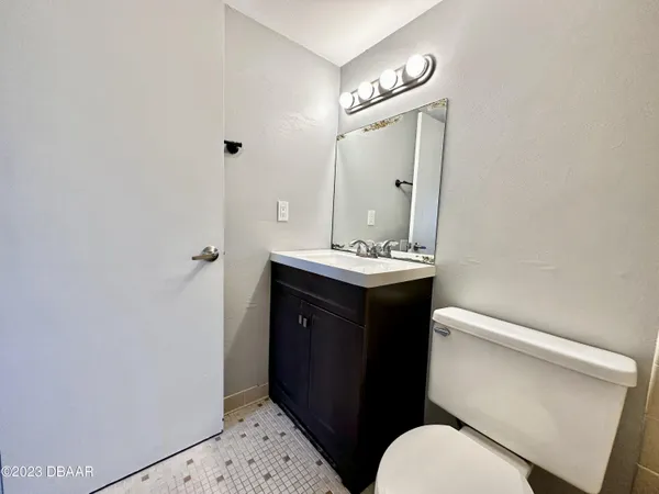 a bathroom with a sink a toilet a mirror and vanity