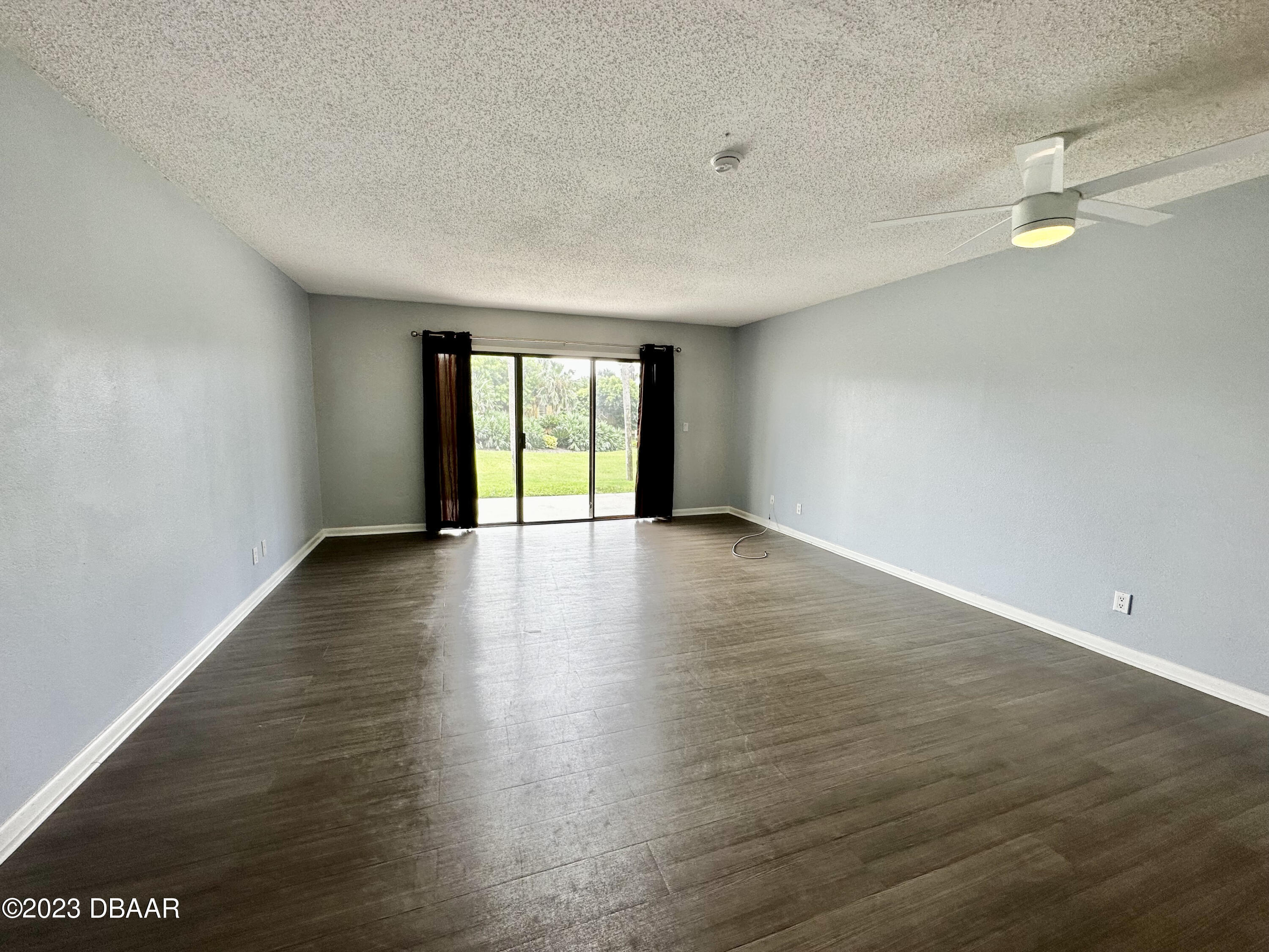 4790 South Atlantic Avenue, Unit D403 Ponce Inlet, FL 32127 - Photo 4 of 27 an empty room with wooden floor and windows