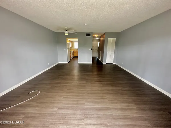 a view of an empty room with wooden floor