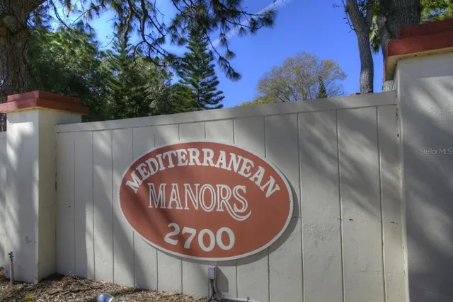 a sign that is on a wooden wall next to a road