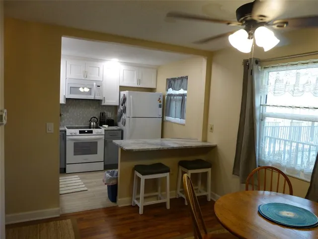 a kitchen with a table chairs refrigerator and cabinets
