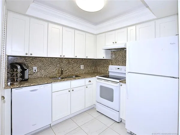 a kitchen with white cabinets and white appliances