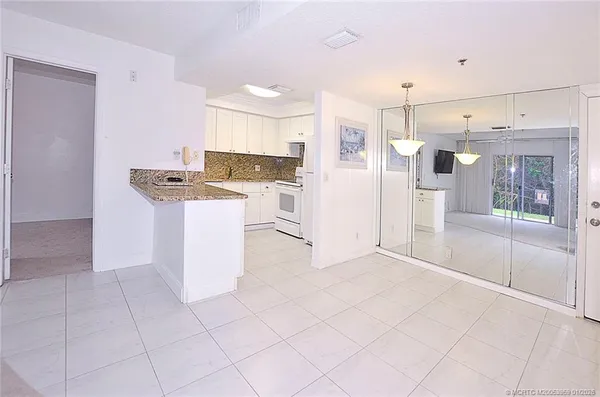a kitchen with white cabinets and white appliances
