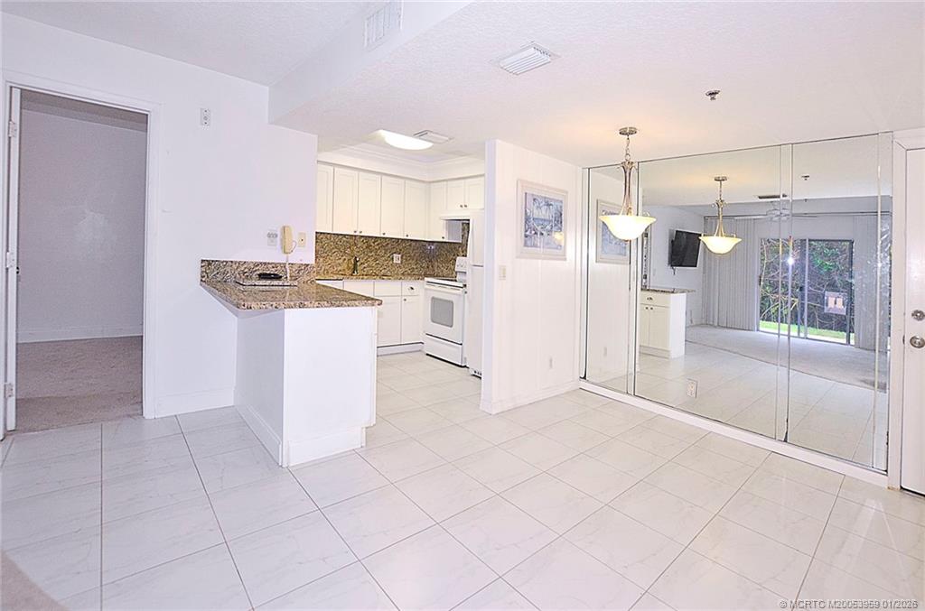 950 South Kanner Highway, Unit 9 Stuart, FL 34994 - Photo 4 of 22 a kitchen with white cabinets and white appliances
