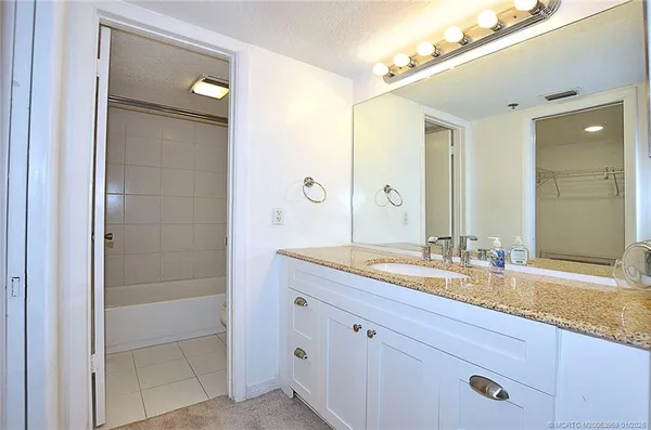 a bathroom with a granite countertop sink mirror and double