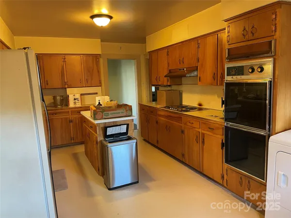 a kitchen with stainless steel appliances granite countertop a stove a sink and a refrigerator