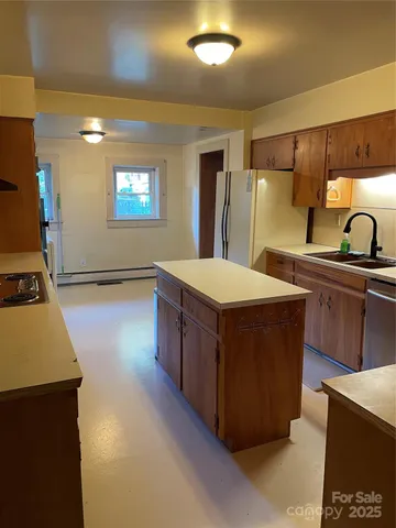 a kitchen with stainless steel appliances granite countertop a sink a stove and a refrigerator