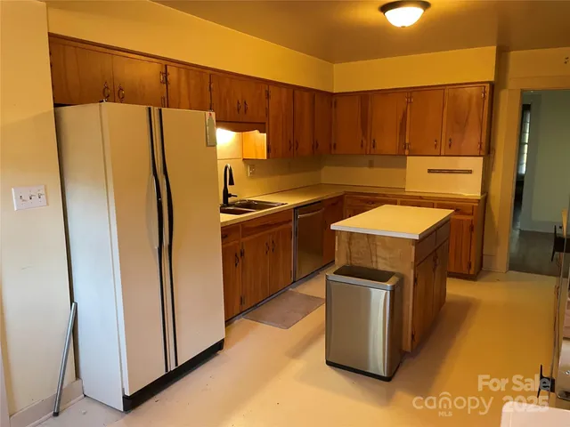 a kitchen that has a sink a refrigerator and a stove