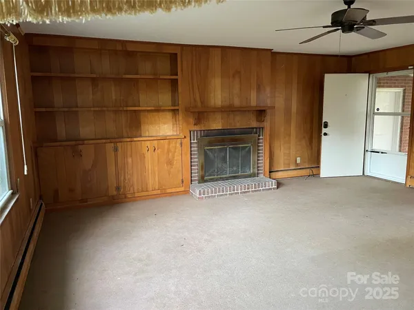 a view of empty room with a fireplace and fan