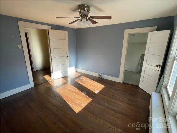 a view of a hallway with wooden floor and stairs