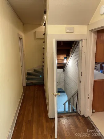 a view of a hallway with wooden floor and staircase