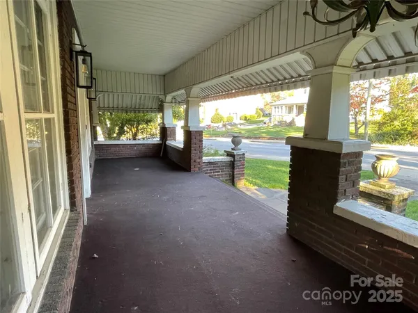 a view of a porch with furniture and floor to ceiling window