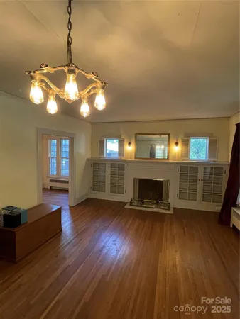 a view of a livingroom with wooden floor a ceiling fan and a window