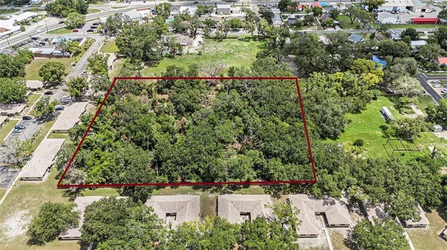 an aerial view of residential house with outdoor space and trees all around