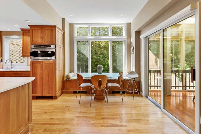 75 Cedar Street Lexington, MA 02421 - Photo 12 of 42 a dining room with stainless steel appliances granite countertop a stove top oven a dining table and chairs with wooden floor