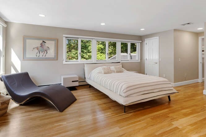 75 Cedar Street Lexington, MA 02421 - Photo 20 of 42 a spacious bedroom with a bed and a chair