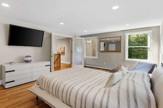 75 Cedar Street Lexington, MA 02421 - Photo 22 of 42 a bedroom with a large bed and a flat screen tv