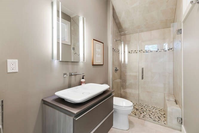 75 Cedar Street Lexington, MA 02421 - Photo 28 of 42 a bathroom with a granite countertop sink toilet a mirror and shower