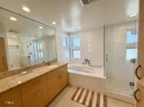 a bathroom with a granite countertop sink mirror and a bath tub