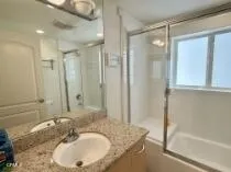 a bathroom with a granite countertop sink mirror and a bath tub