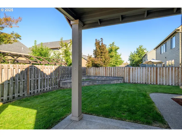 a view of a backyard with wooden fence
