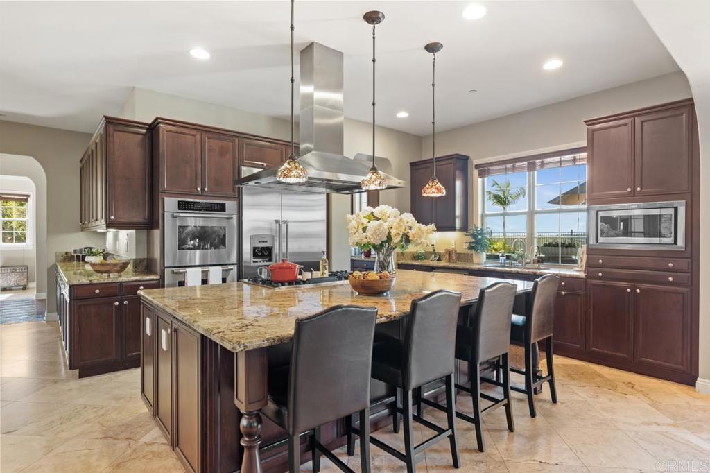 14844 Whispering Ridge Road San Diego, CA 92131 - Photo 25 of 73 a kitchen with stainless steel appliances granite countertop table chairs and a refrigerator