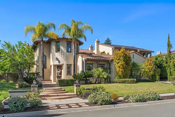 a front view of a house with a yard and potted plants