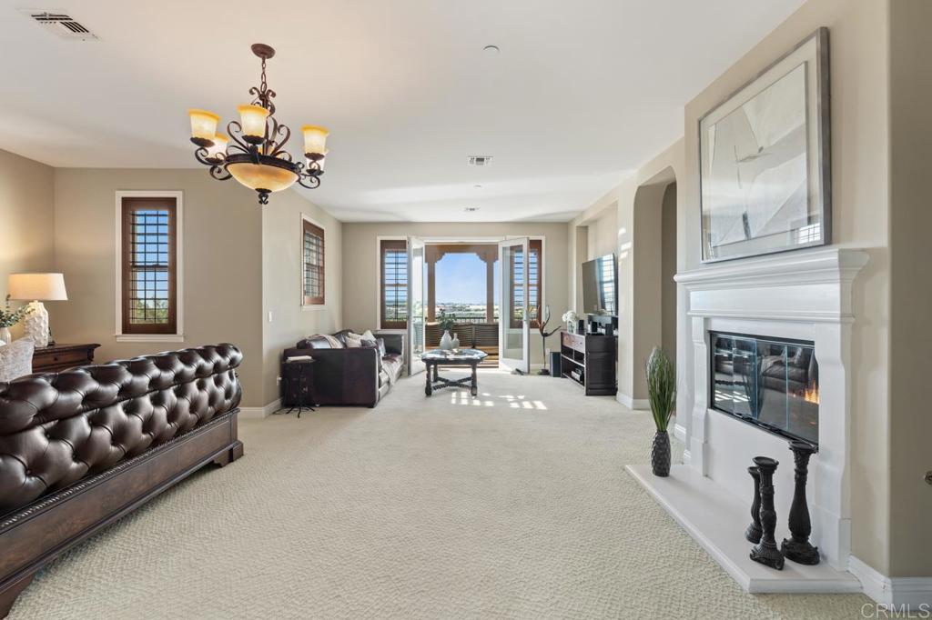 14844 Whispering Ridge Road San Diego, CA 92131 - Photo 49 of 73 a living room with furniture a fireplace and chandelier