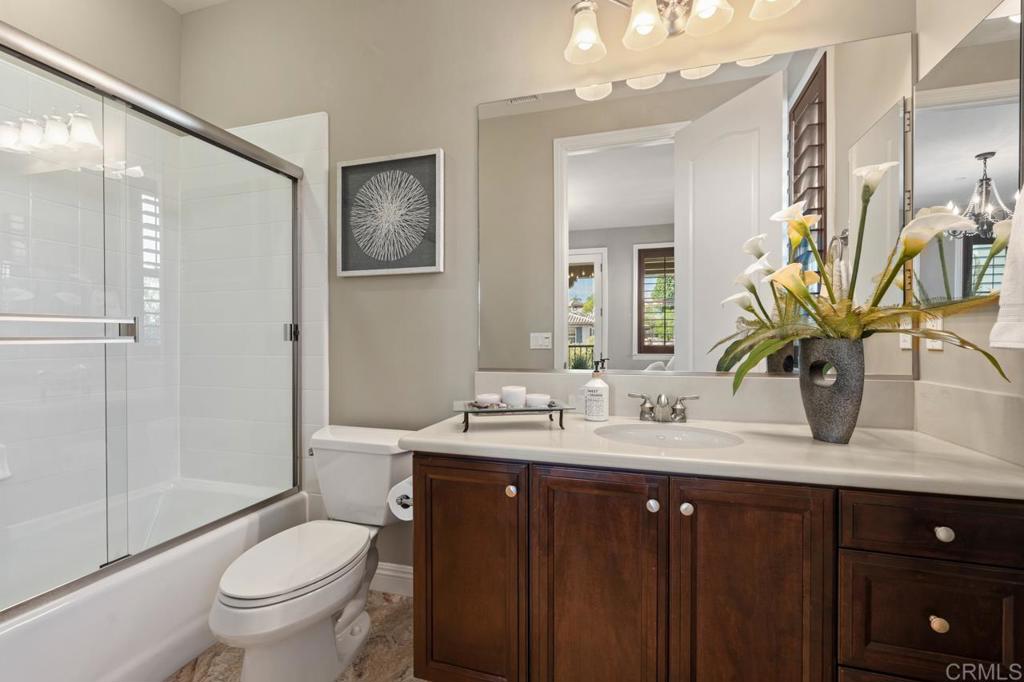 14844 Whispering Ridge Road San Diego, CA 92131 - Photo 65 of 73 a bathroom with a granite countertop sink a toilet a mirror and shower