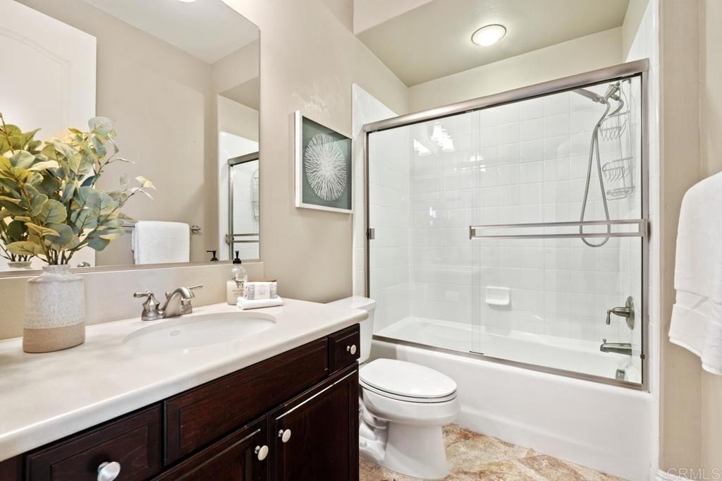 14844 Whispering Ridge Road San Diego, CA 92131 - Photo 69 of 73 a bathroom with a sink a toilet a mirror and shower