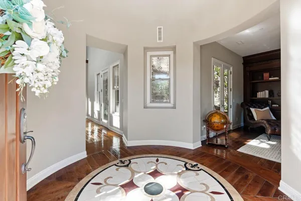a view of a hallway with wooden floor and staircase