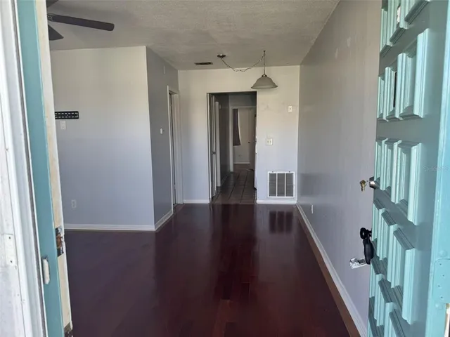 a view of hallway with stairs and wooden floor