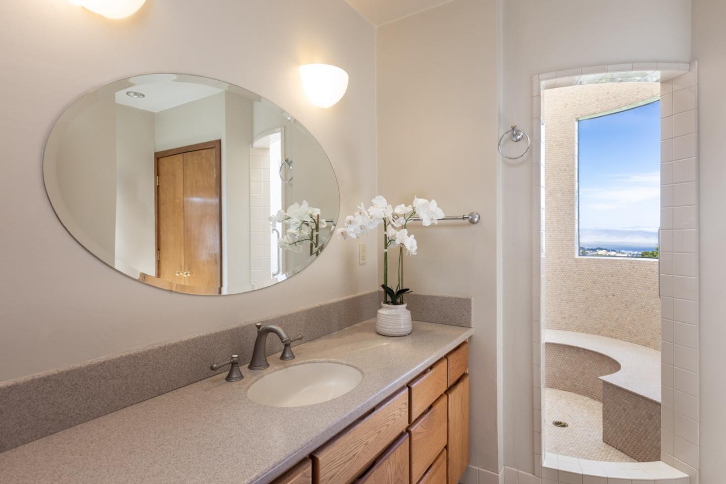 540 Aguajito Road Carmel, CA 93923 - Photo 26 of 32 a bathroom with a granite countertop sink and a mirror