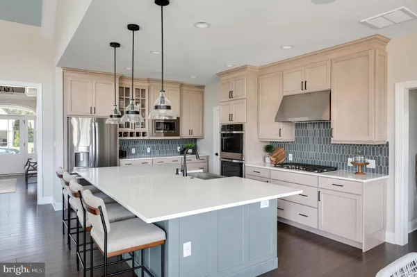 a kitchen with stainless steel appliances a stove a sink a oven a table and chairs