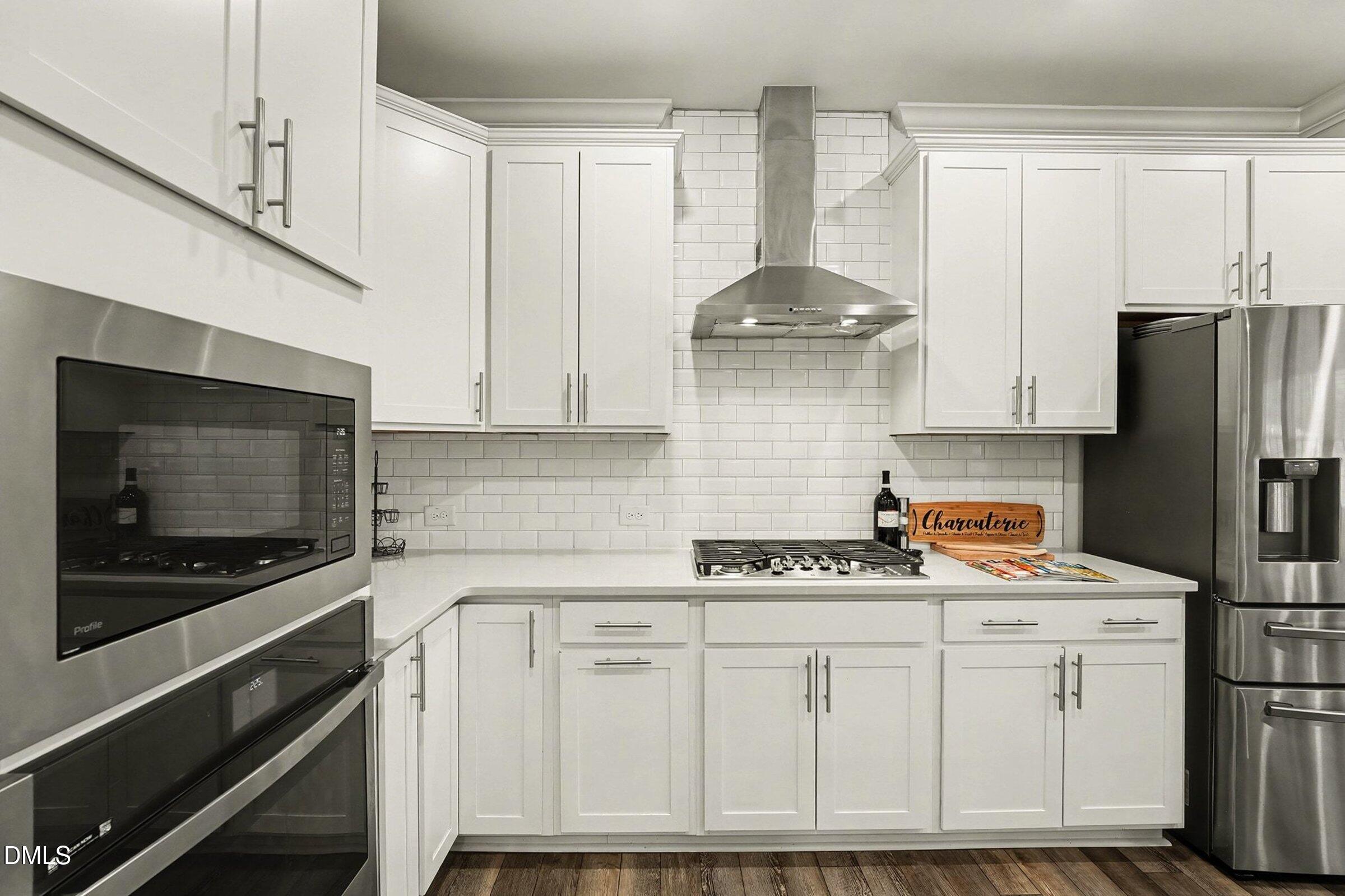 183 Axis Deer Lane Garner, NC 27529 - Photo 11 of 35 a kitchen with stainless steel appliances a stove a refrigerator a sink and cabinets