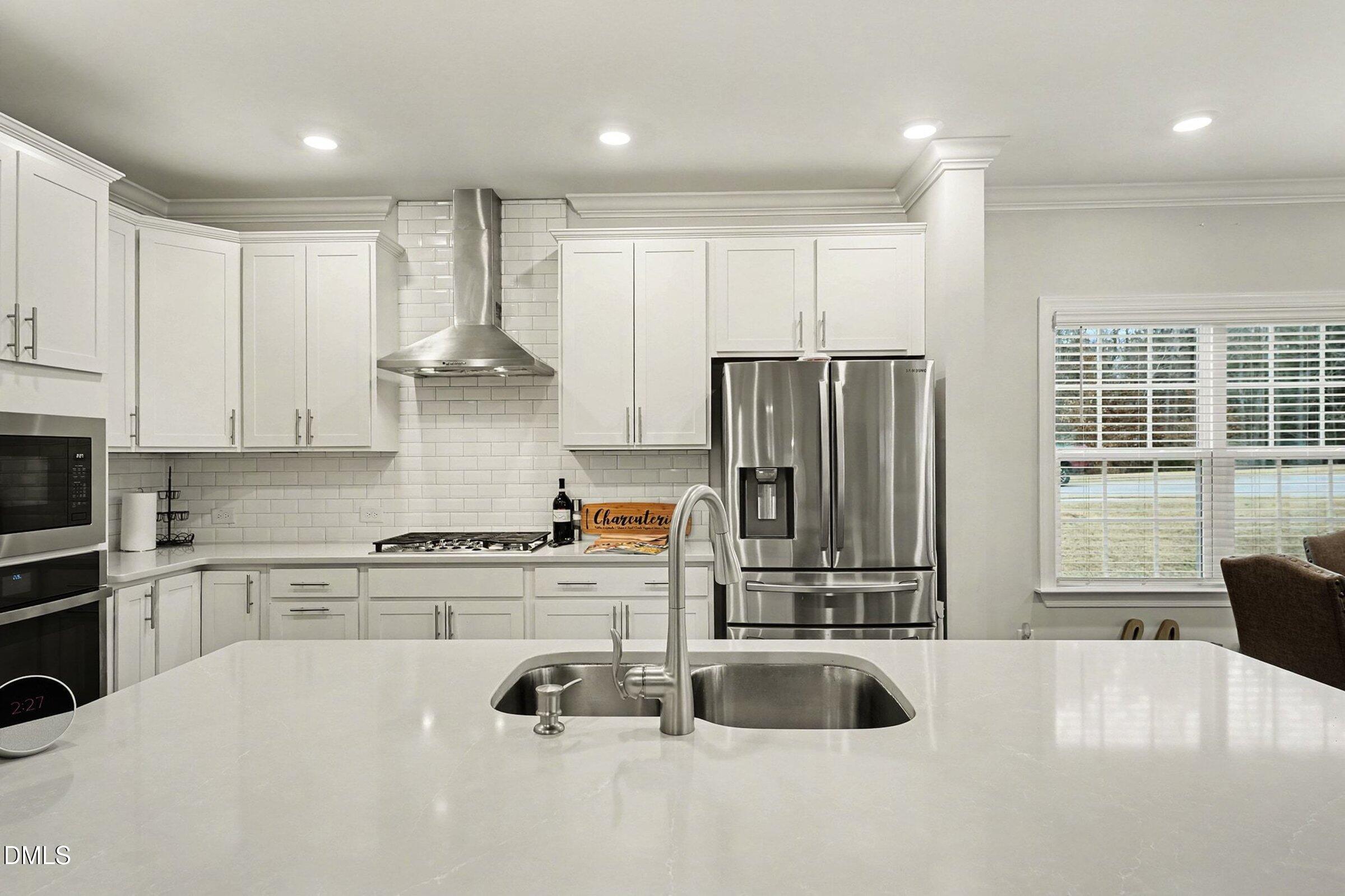 183 Axis Deer Lane Garner, NC 27529 - Photo 12 of 35 a kitchen with stainless steel appliances granite countertop a sink refrigerator and cabinets