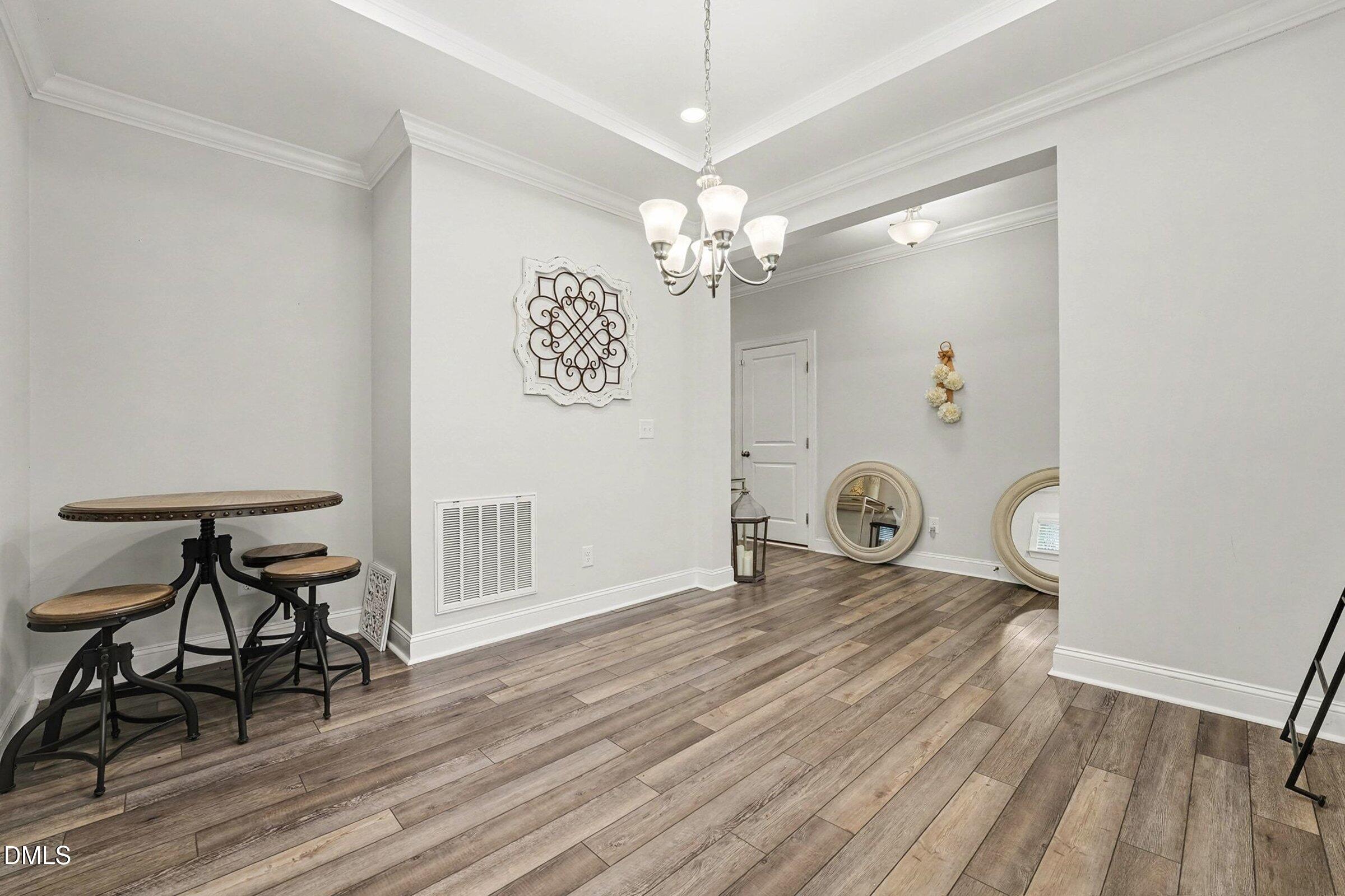 183 Axis Deer Lane Garner, NC 27529 - Photo 16 of 35 a view of a room with wooden floor and chandelier
