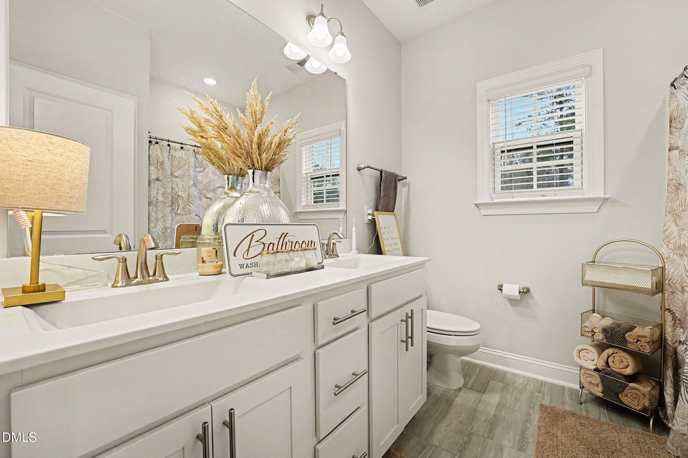 183 Axis Deer Lane Garner, NC 27529 - Photo 18 of 35 a bathroom with a sink a toilet and a mirror