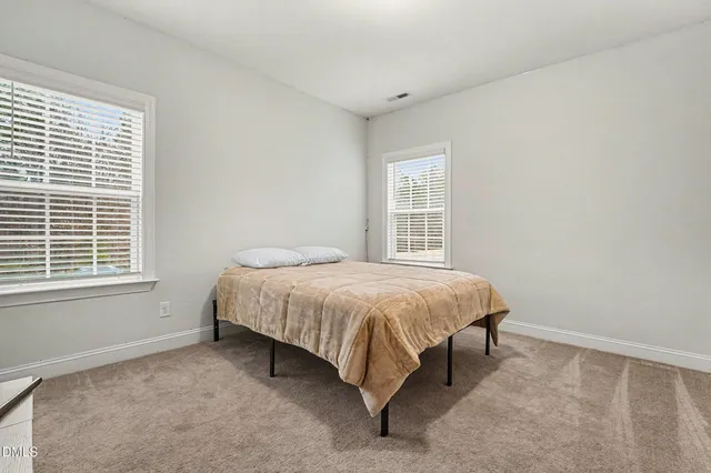 a bed sitting in a bedroom next to a window