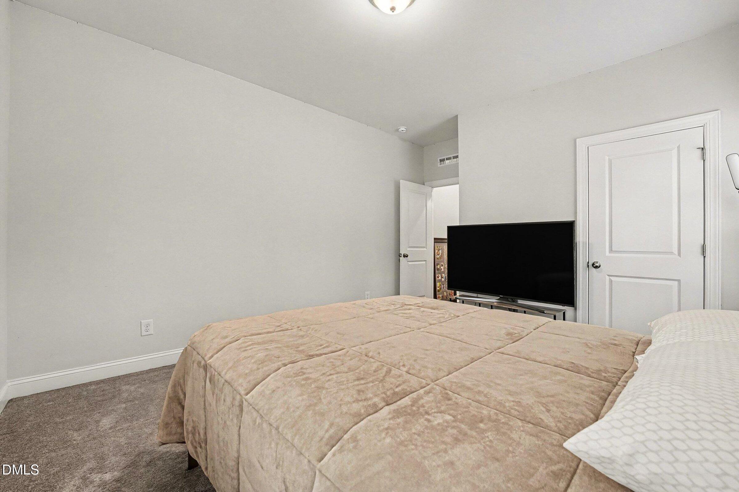 183 Axis Deer Lane Garner, NC 27529 - Photo 20 of 35 a bedroom with a bed and a flat screen tv