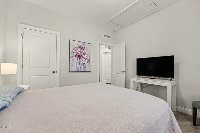 a bedroom with a flat screen tv and a bed