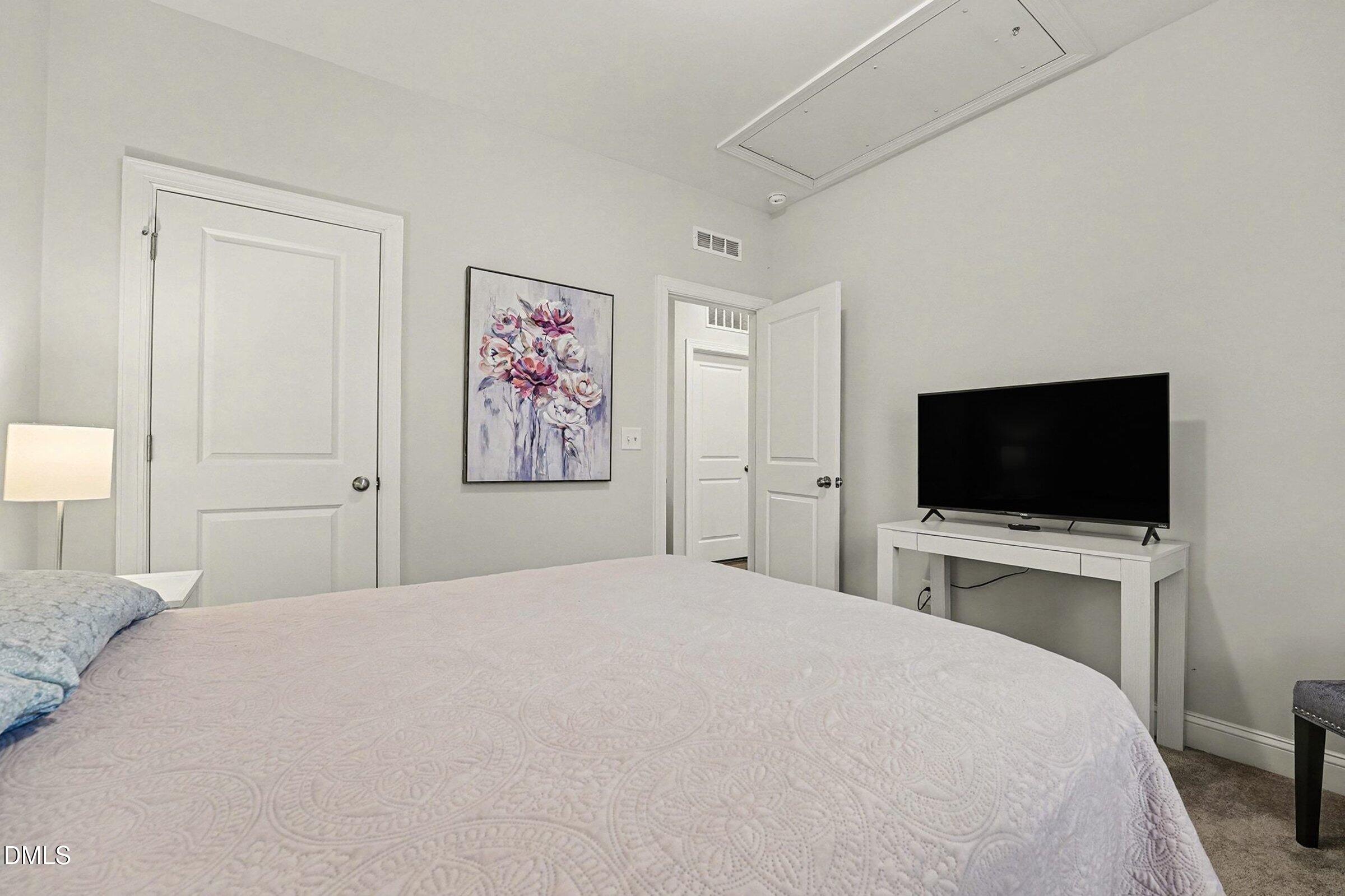 183 Axis Deer Lane Garner, NC 27529 - Photo 22 of 35 a bedroom with a flat screen tv and a bed