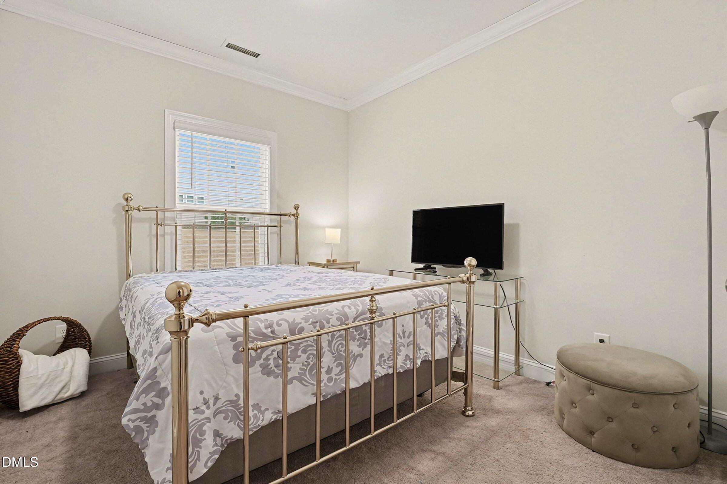 183 Axis Deer Lane Garner, NC 27529 - Photo 30 of 35 a bedroom with a bed and a flat screen tv