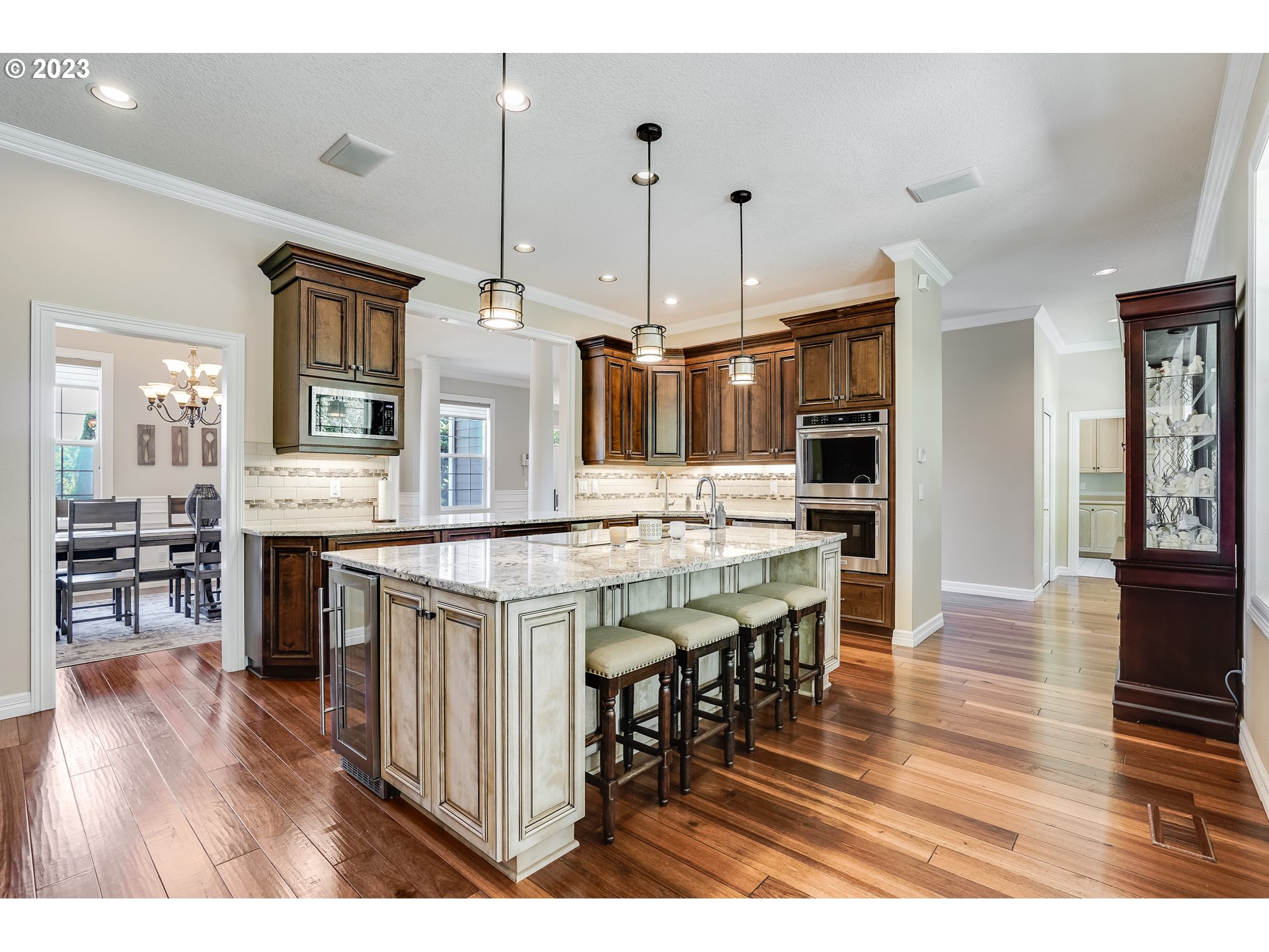 21418 Northwest 11th Avenue Ridgefield, WA 98642 - Photo 9 of 42 a kitchen with stainless steel appliances granite countertop a kitchen island a stove a table and chairs