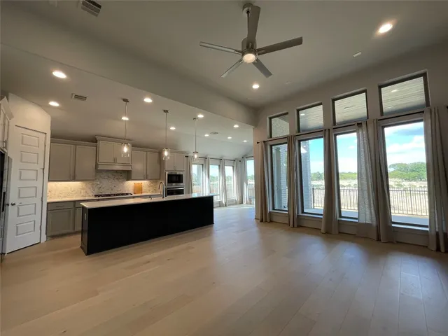 a kitchen with kitchen island a sink a center island and wooden floor